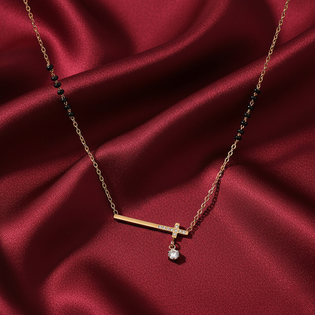 Traditional mangalsutra design with gold bar pendant, solitaire drop, and black beads on red satin fabric