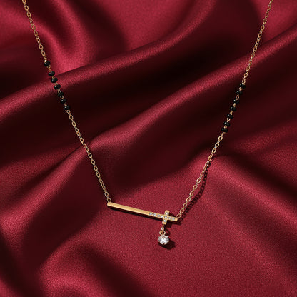 Traditional mangalsutra design with gold bar pendant, solitaire drop, and black beads on red satin fabric