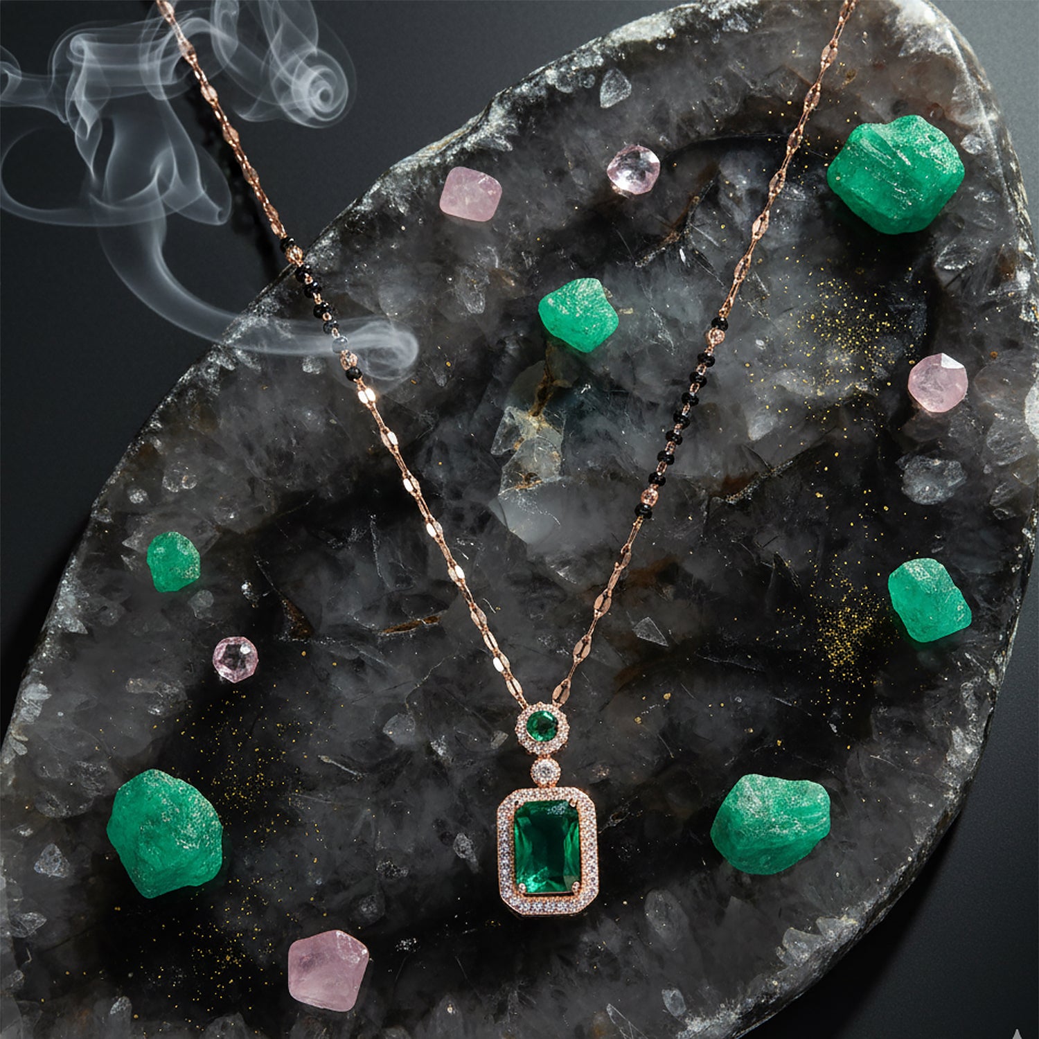 Gold black-beads mangalsutra with an emerald pendant displayed on a stone backdrop with green and pink crystals