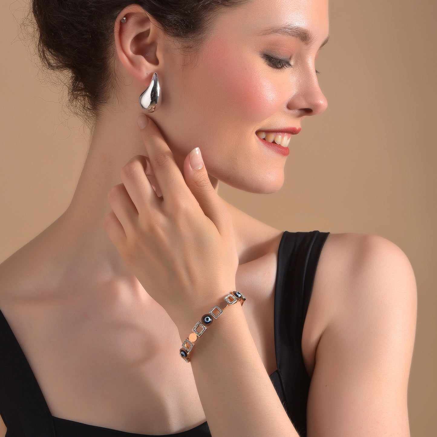 A premium gold bracelet for women with alternating square and circular evil eye links.