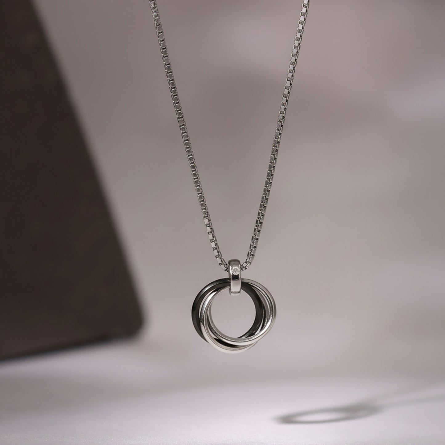 Silver chain necklace with polished interlocking ring pendant