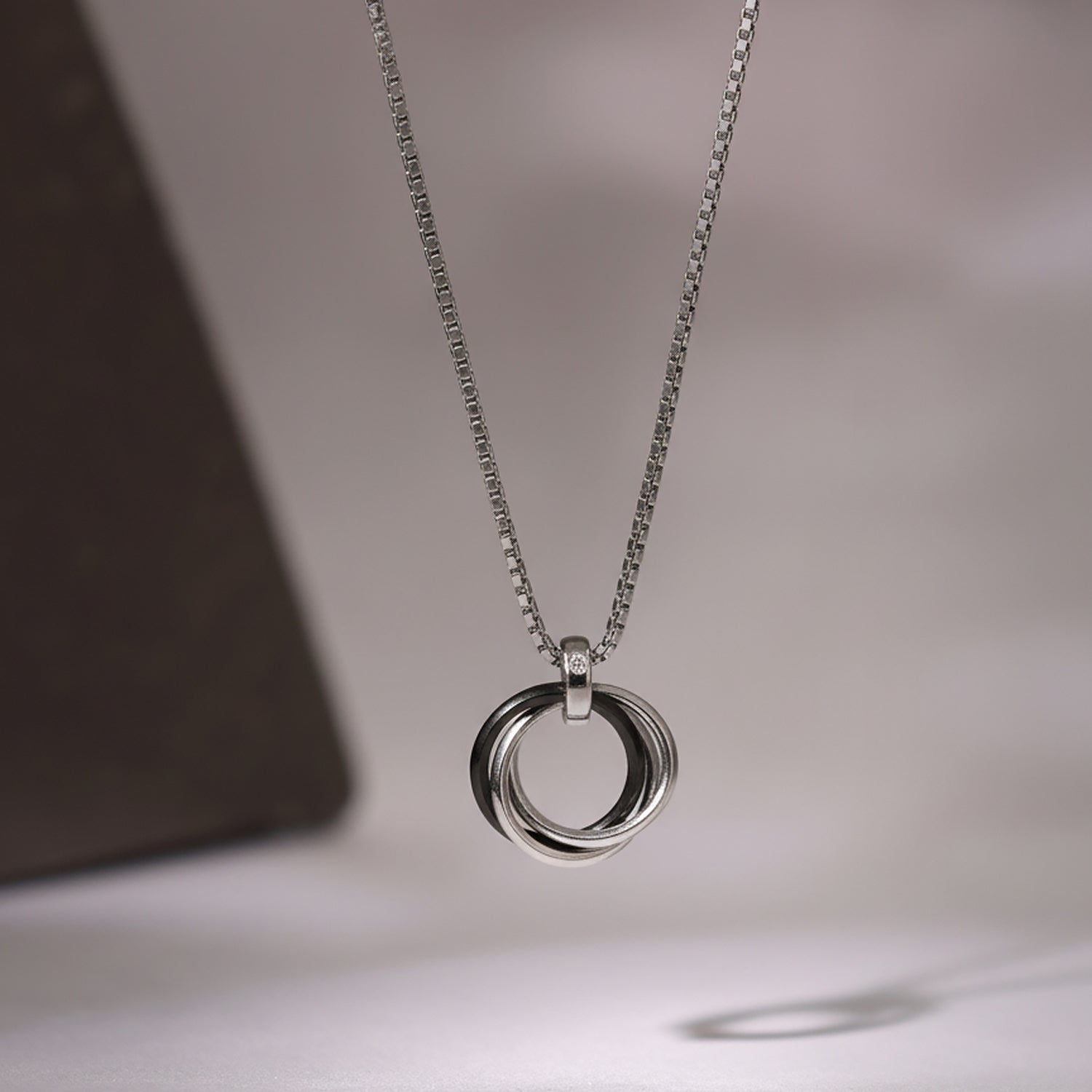 Silver chain necklace with polished interlocking ring pendant