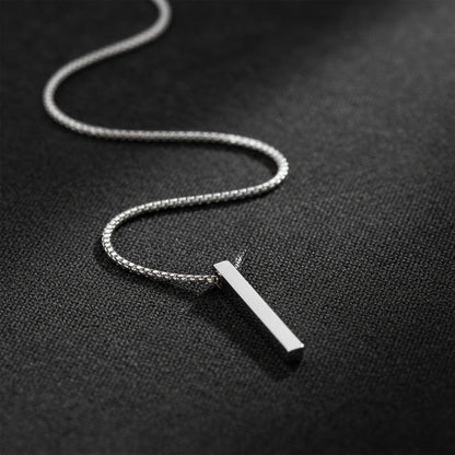 Men’s silver chain necklace with a sleek bar pendant on a dark textured background