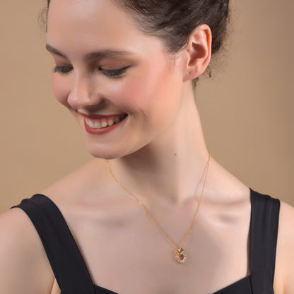 A woman showcasing one of the latest gold necklace designs featuring a delicate chain and a circular pendant 