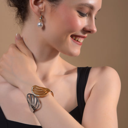 A stylish gold bracelet design for women worn by a model, featuring a bold overlapping mixed-metal aesthetic.