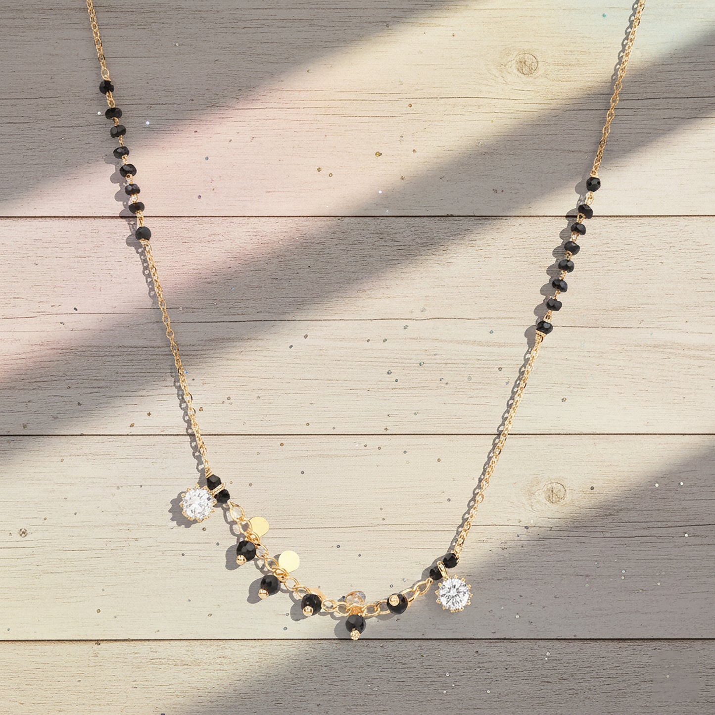 Small mangalsutra design in gold with black beads and crystal charm