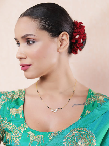 “Woman showcasing the latest gold mangalsutra design with minimal black beads and a delicate CZ pendant