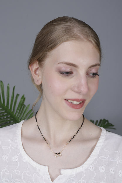 Gold mangalsutra with dual floral pendant on a black bead chain