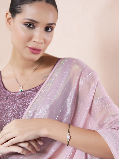 Woman wearing a diamond mangalsutra design paired with a shimmery pink saree, showcasing the matching bracelet.