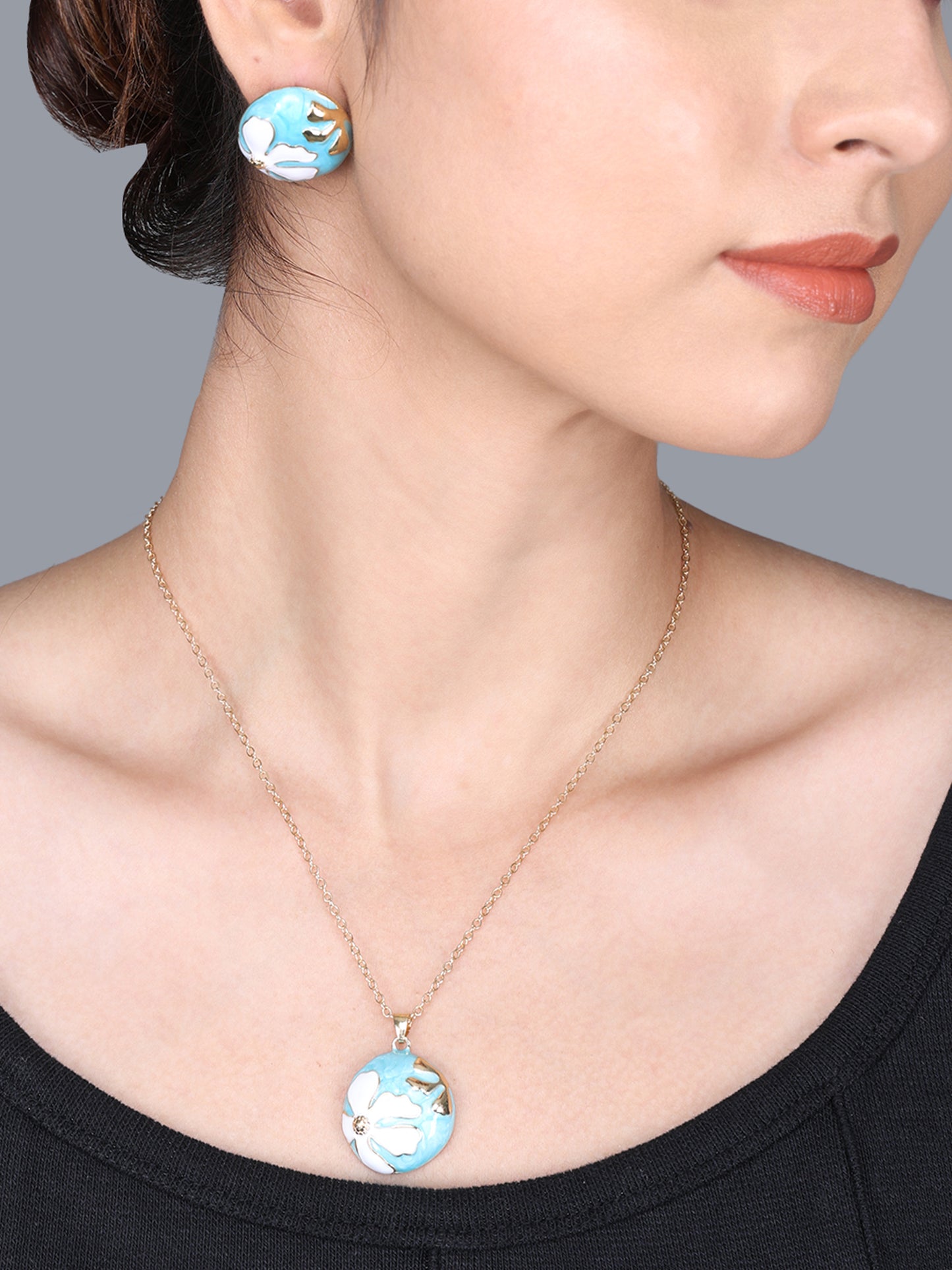 Small gold necklace design with a round turquoise and white enamel floral pendant