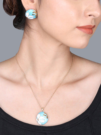 Small gold necklace design with a round turquoise and white enamel floral pendant