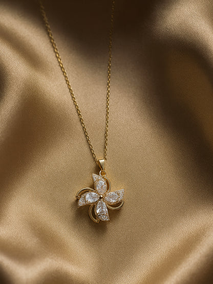Close-up of a shimmering gold necklace design with a rotating floral pendant and a fine link chain, highlighting the intricate crystal pavé work