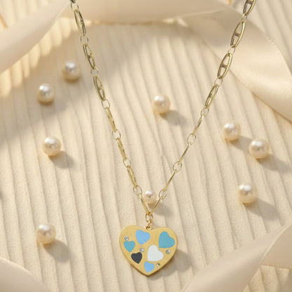 Aesthetic gold necklace for women surrounded by pearls, featuring a heart pendant with blue, white, and black enamel.