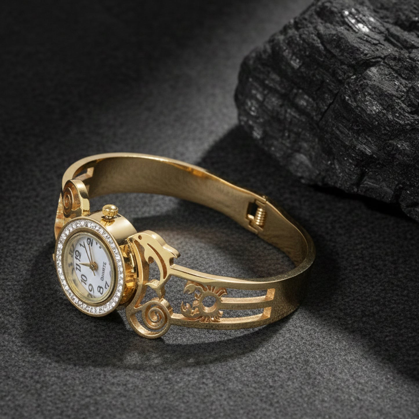 Luxury gold plated bracelet for ladies displayed on a dark textured background to highlight the metallic shine.