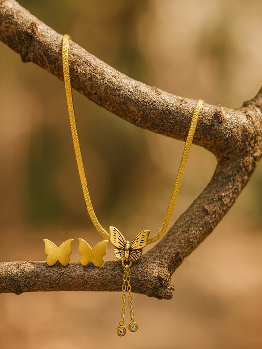 Gold butterfly necklace design with matching stud earrings displayed on a branch
