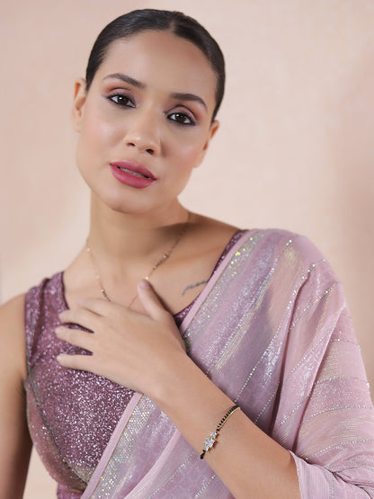 Elegant gold bracelet design for women styled with a glittery blouse and pastel saree.