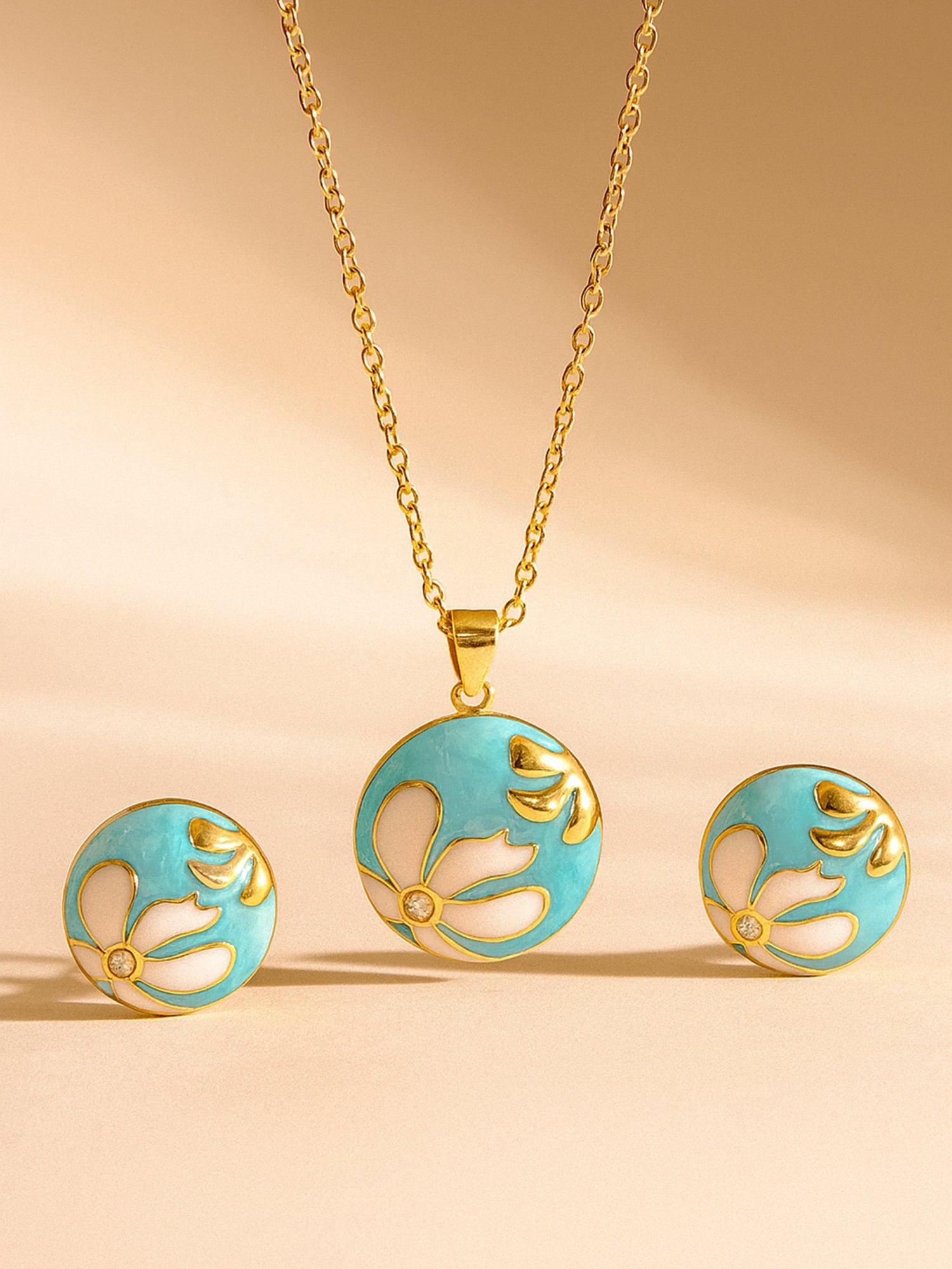 Stylish gold necklace for women with a round turquoise and white floral enamel pendant and stud earrings