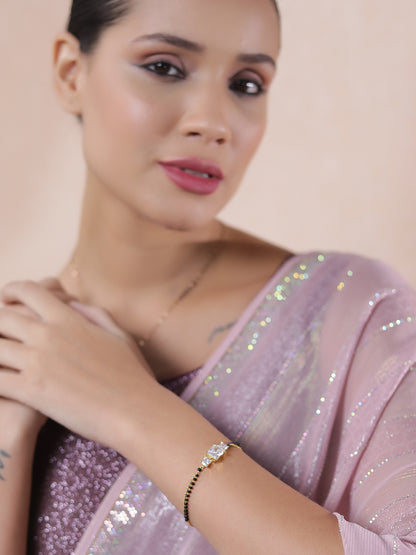 Elegant mangalsutra latest design gold bracelet for women styled with a shimmery pink saree.