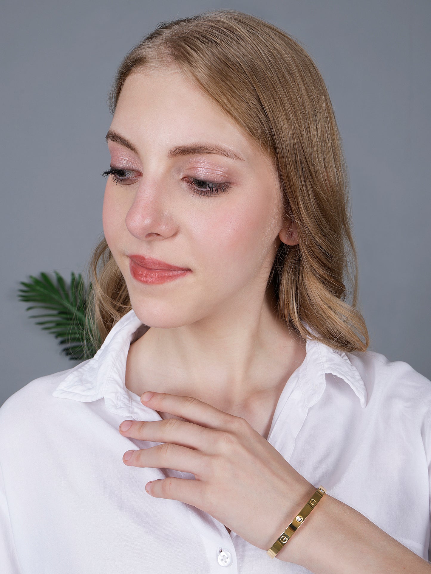 A model showcasing the latest bracelet design featuring a sleek bangle silhouette and subtle gemstone detailing.