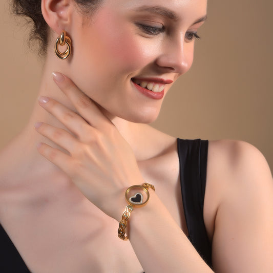 Woman wearing a stylish gold bracelet design for women with a heart charm.