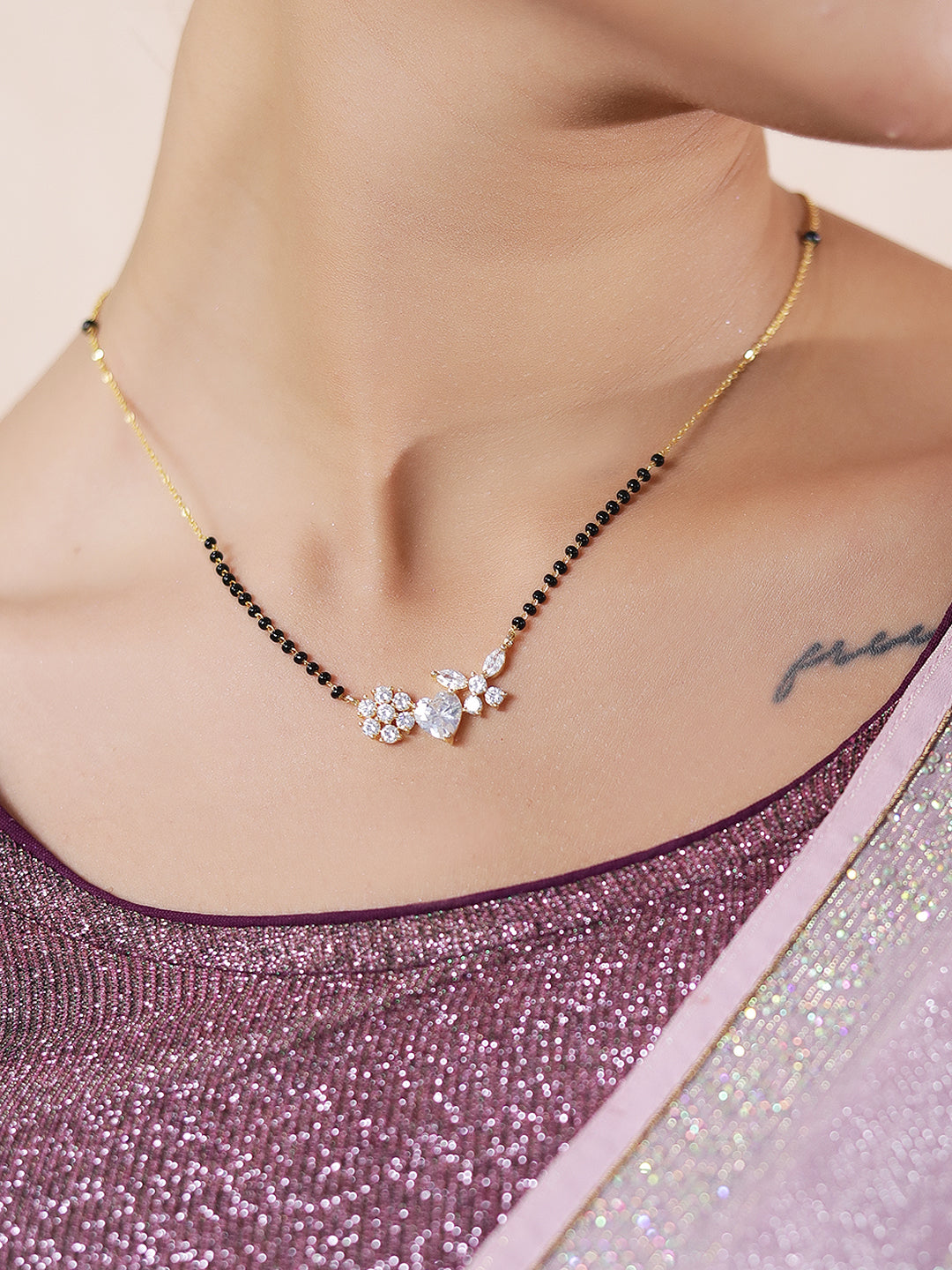 Mangalsutra pendant design in gold with heart and flower on woman