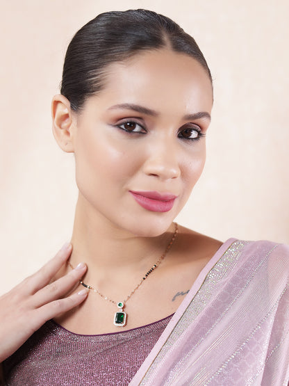 Model wearing a gold mangalsutra design with an emerald pendant, showcasing the latest mangalsutra trend