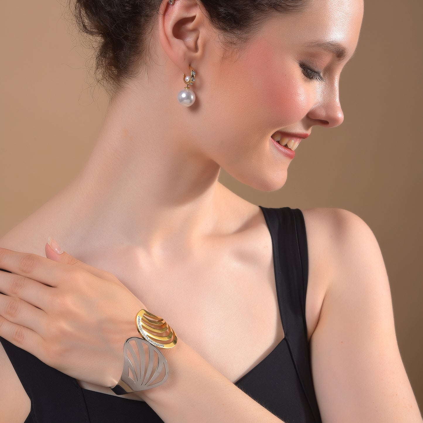 Elegant gold plated bracelet for ladies paired with pearl earrings for a sophisticated evening look