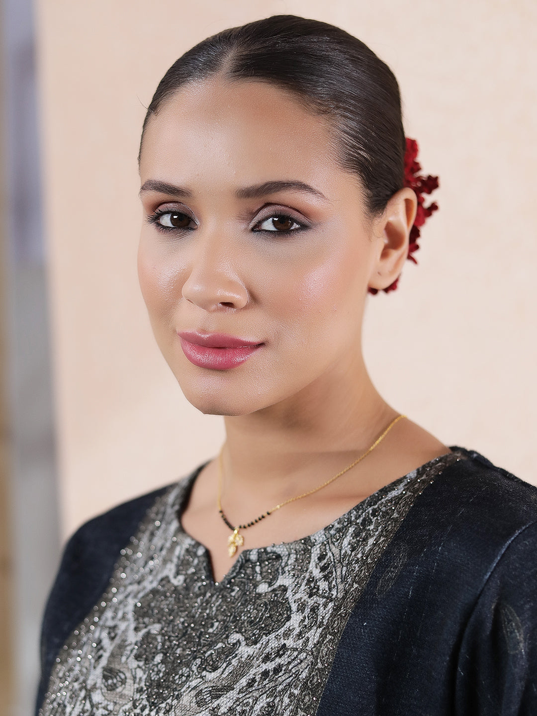 Woman wearing a gold Hindu mangalsutra design with a delicate chain and small pendant, styled with traditional attire