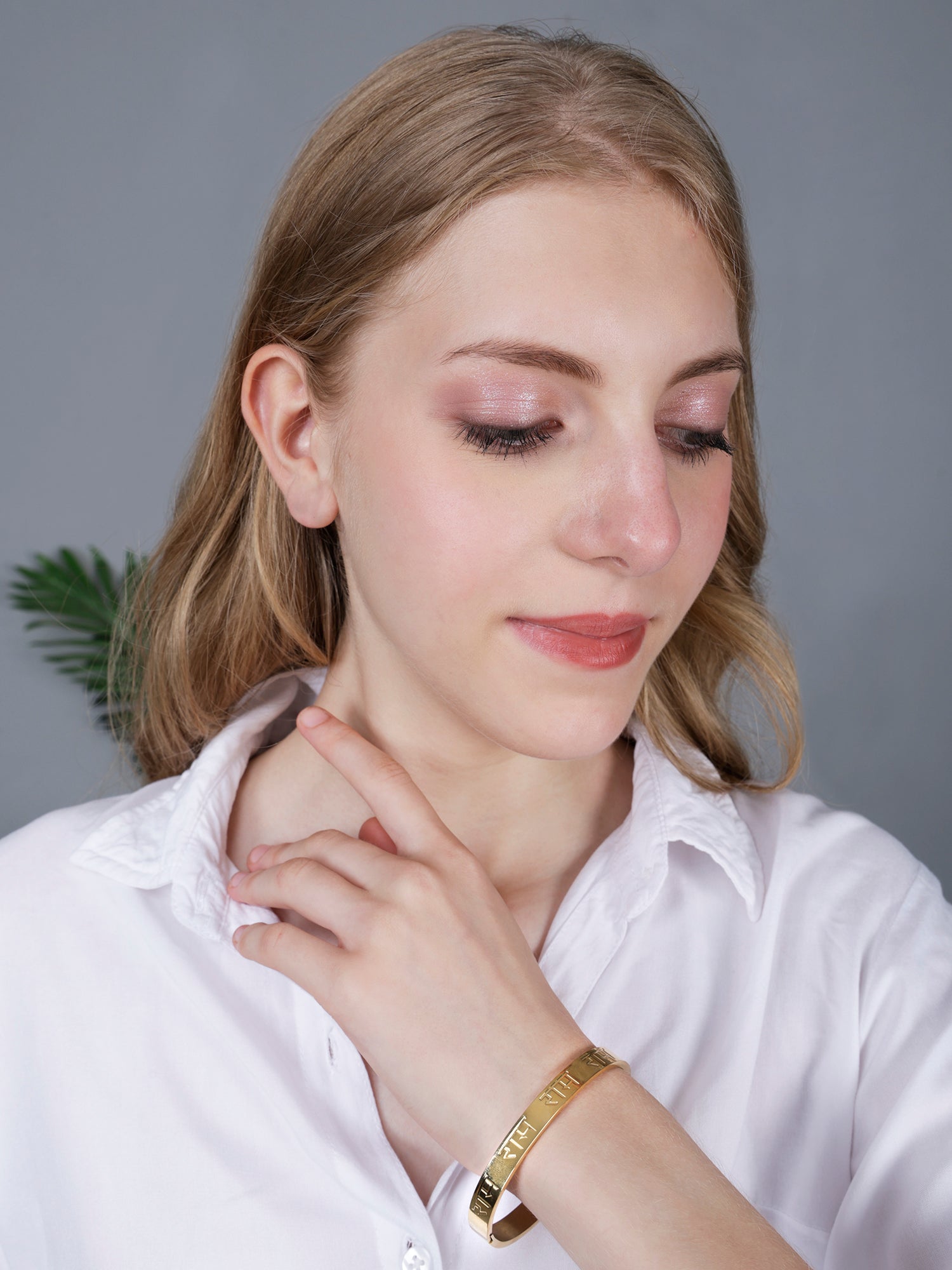 A model wearing a spiritual hand bracelet for women featuring a minimalist gold plated design.