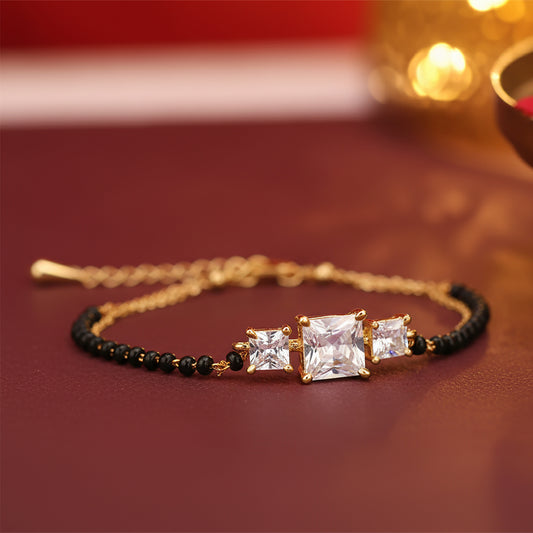 Elegant hand bracelet mangalsutra  with gold chain, black beads, and square-cut stones 
