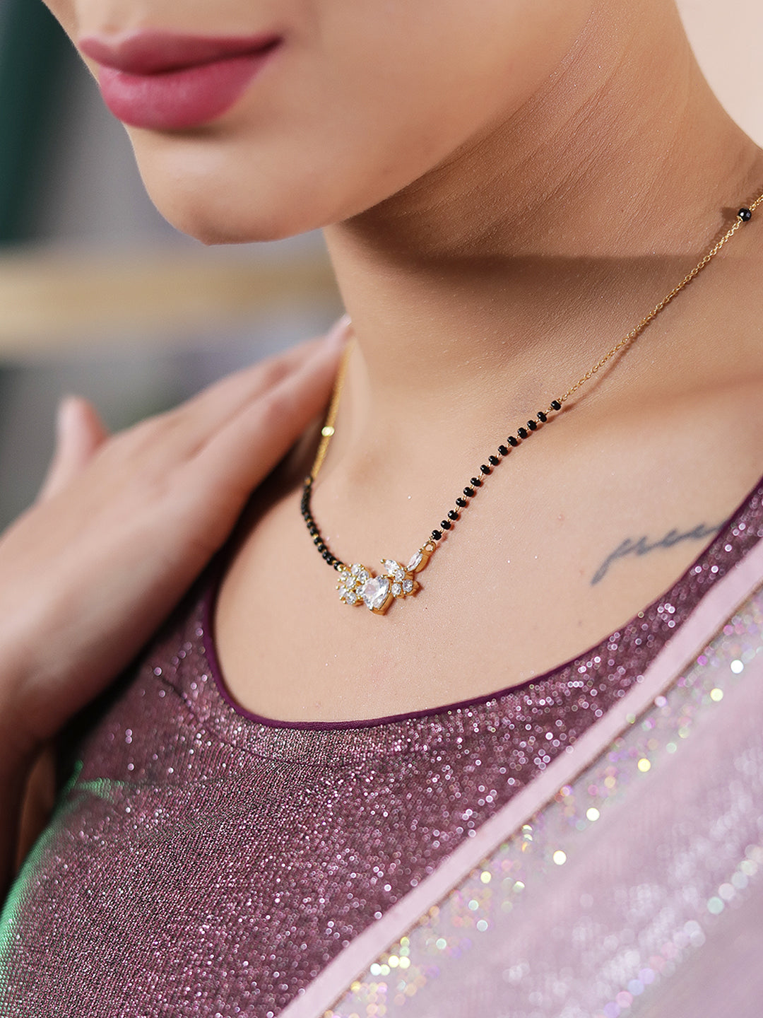 Gold mangalsutra pendant on woman with heart and flower motif