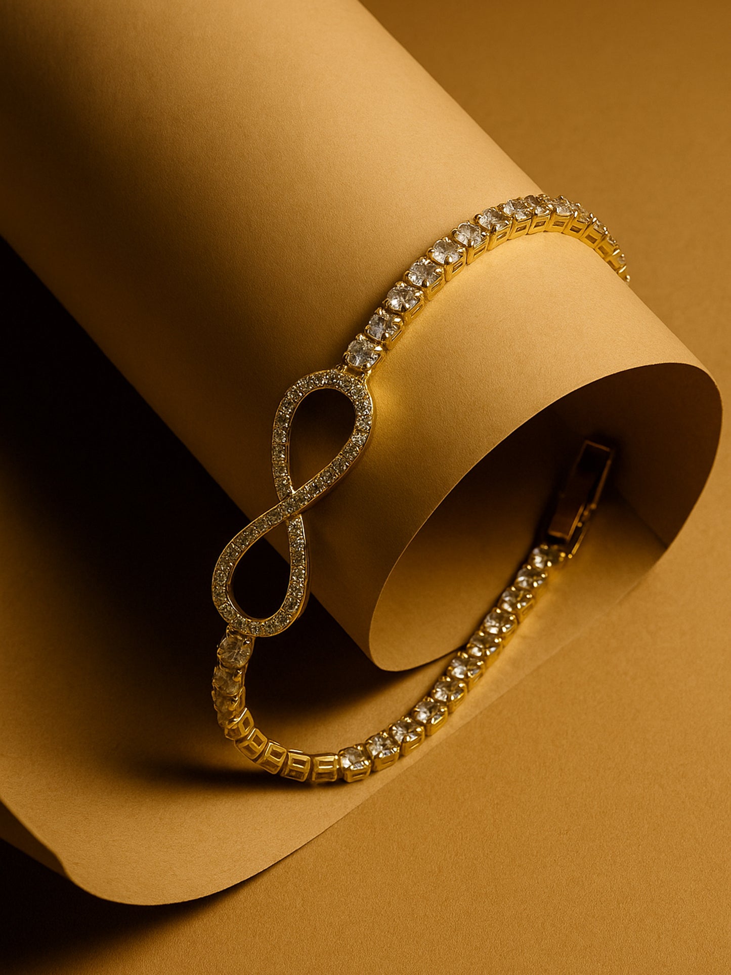 Gold plated bracelet for ladies with sparkling stones displayed on an elegant tan paper roll.