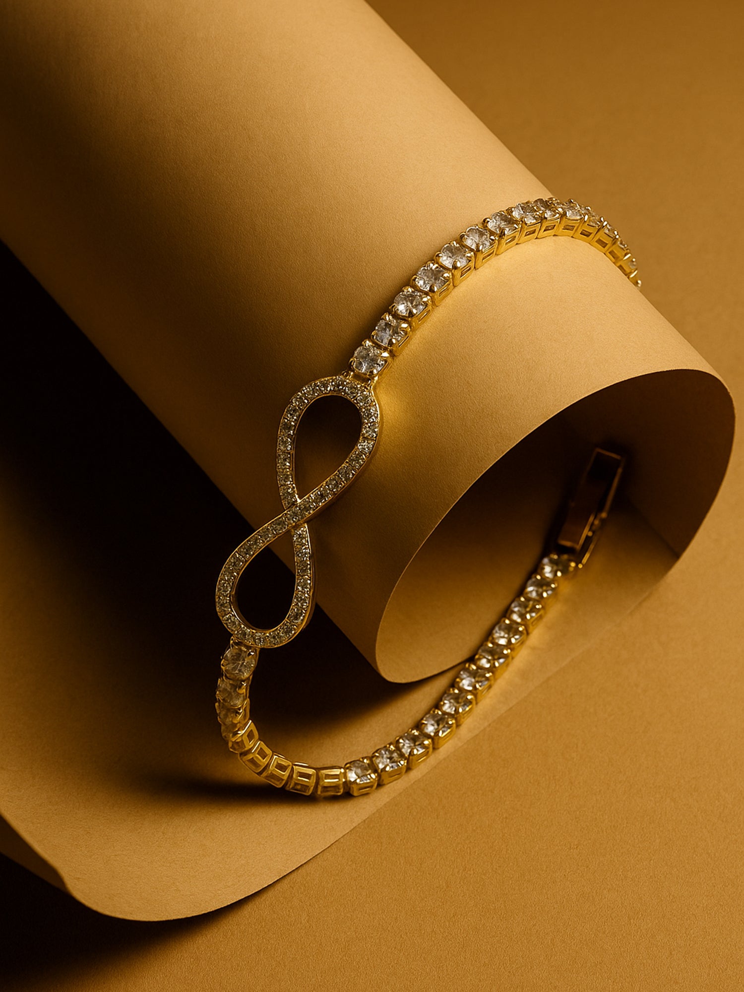 Gold plated bracelet for ladies with sparkling stones displayed on an elegant tan paper roll.