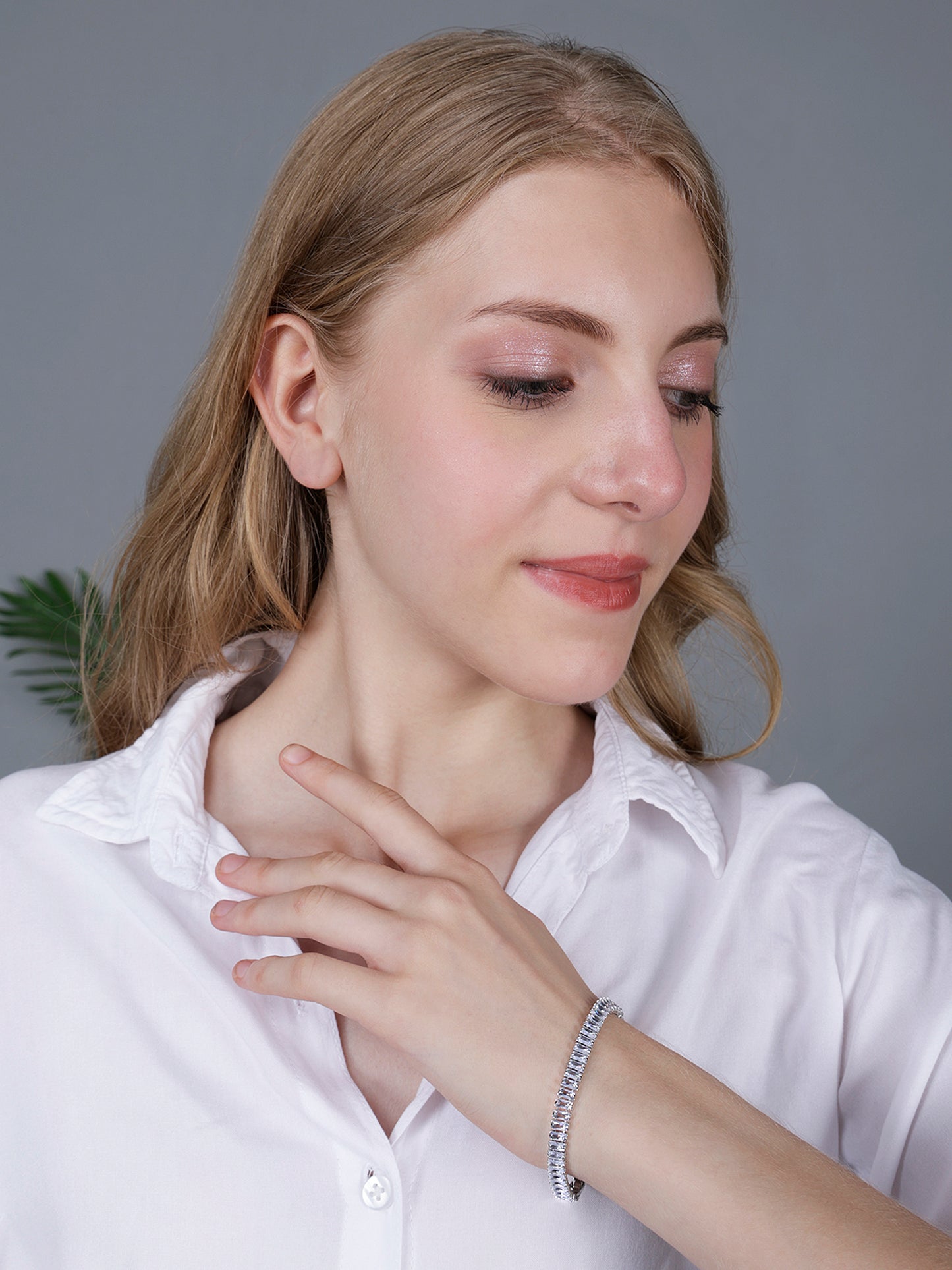 Ladies bracelet in silver worn on a wrist, styled with a white button-down shirt for a sophisticated look.