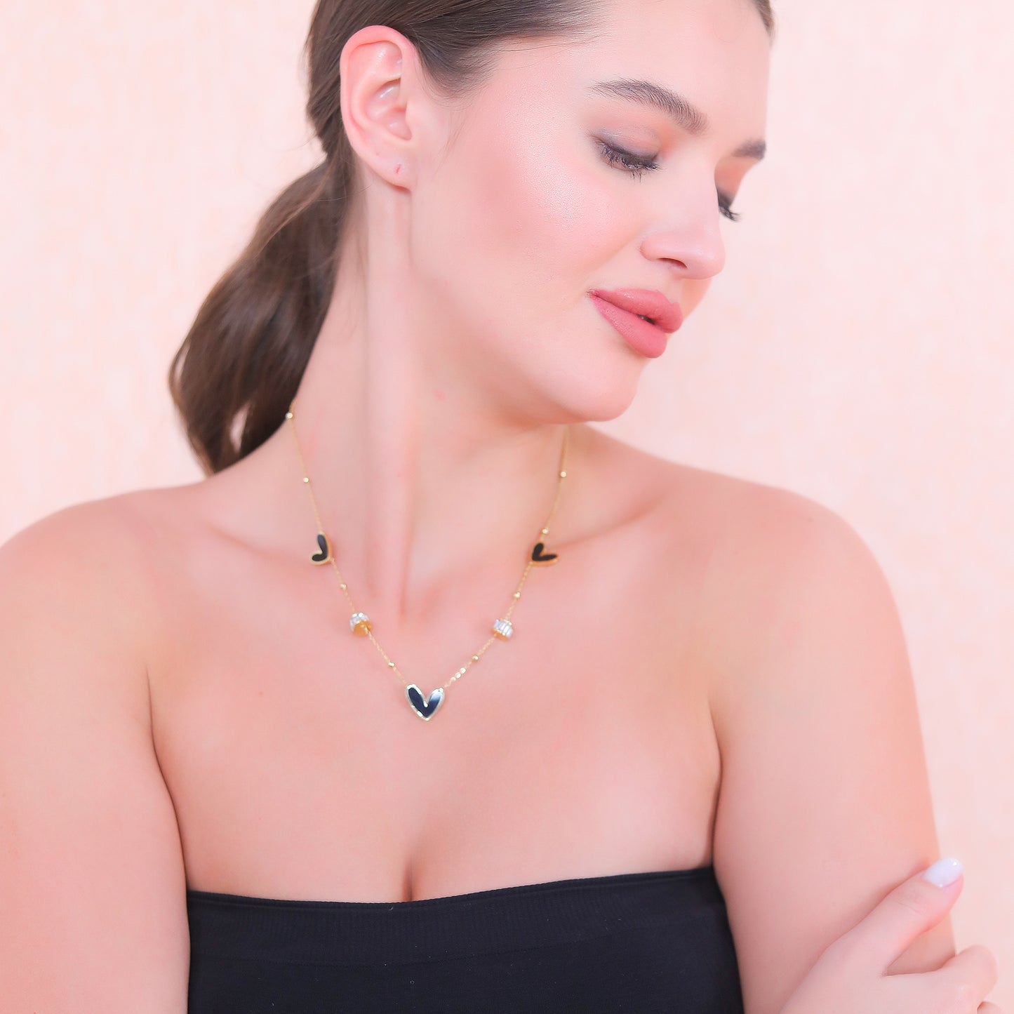 Latest gold necklace designs featuring multiple heart pendants worn by a model in a lifestyle shot.