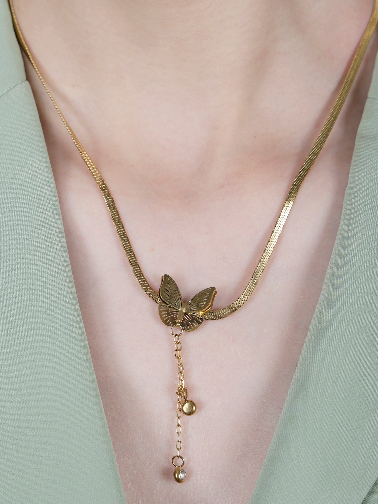 Latest gold necklace designs featuring a snake chain, butterfly pendant with dangle, and matching earrings