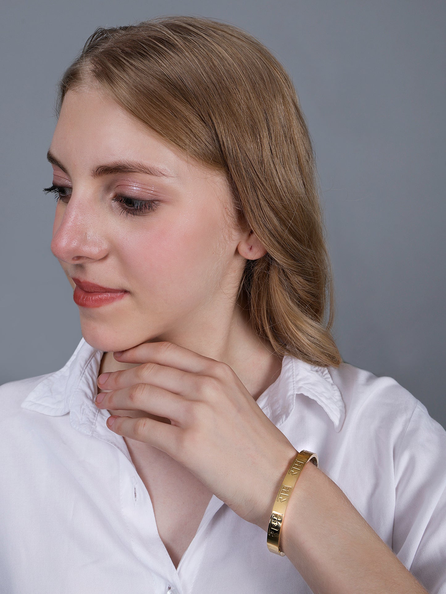 Side view of a model showcasing the latest bracelet design in gold with a side-clasp mechanism.