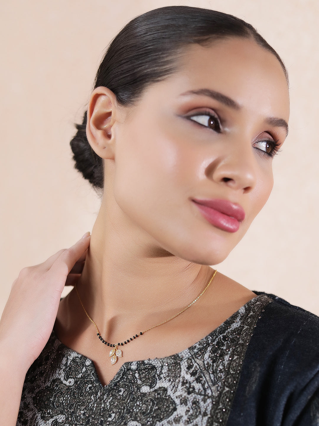 Woman wearing a simple modern mangalsutra design with a crystal leaf pendant