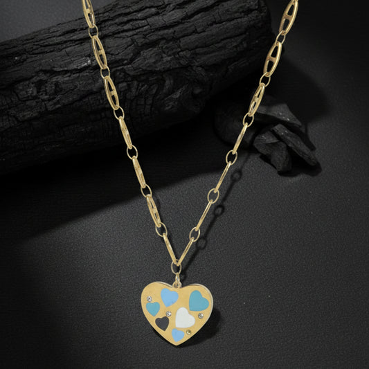 Light weight gold necklace with a decorative heart charm and small crystals, placed on a textured charcoal surface.
