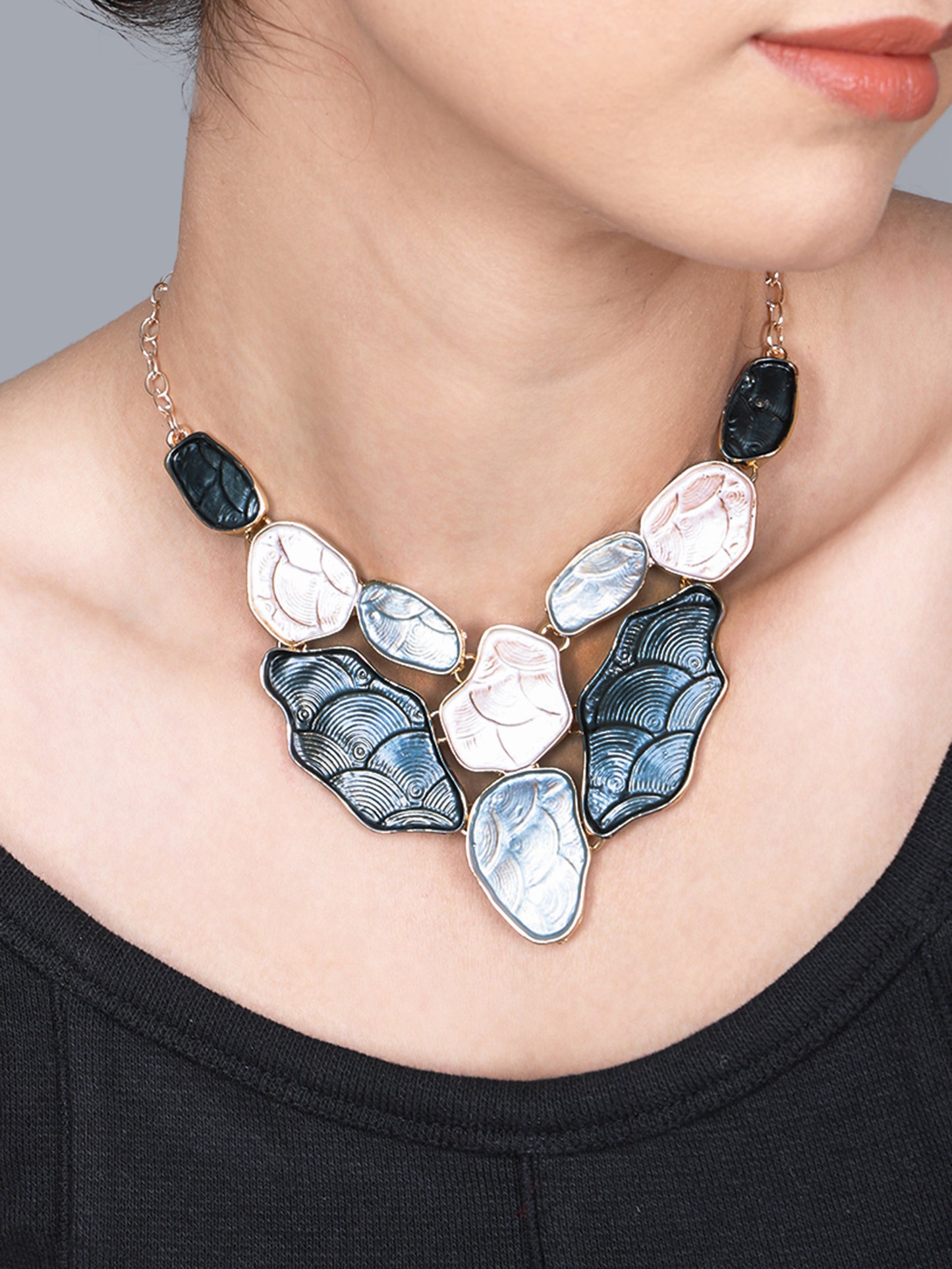 High-detail close-up of a light weight gold necklace showcasing the intricate wave textures and enamel work.