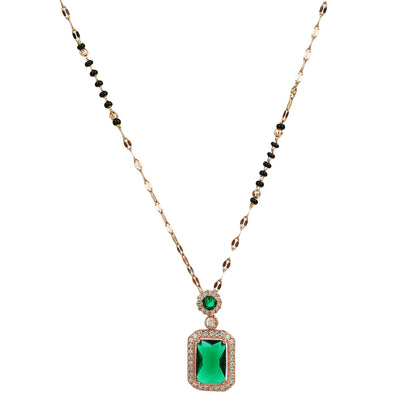 Gold Hindu mangalsutra design with black beads and an emerald green pendant on a white background