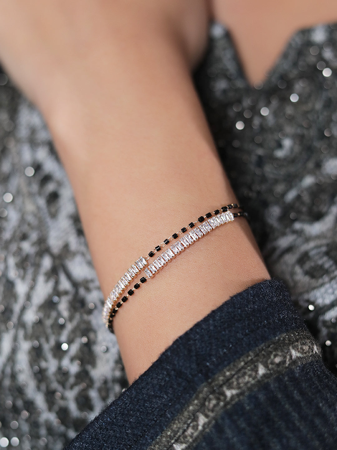 Gold mangalsutra latest design bracelet with black beads and elegant stone detailing on wrist.