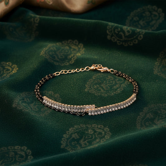 Elegant mangalsutra bracelet design with black beads and gold bar.