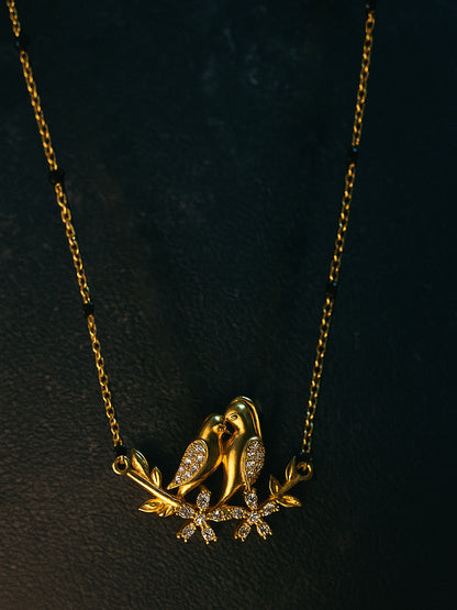 Delicate gold chain with black beads and a diamond-accented twin love birds pendant