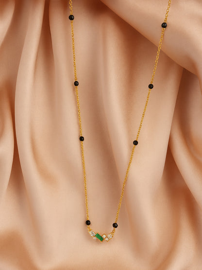 Elegant Black Beads Mangalsutra Gold Necklace on a Cream Fabric Background