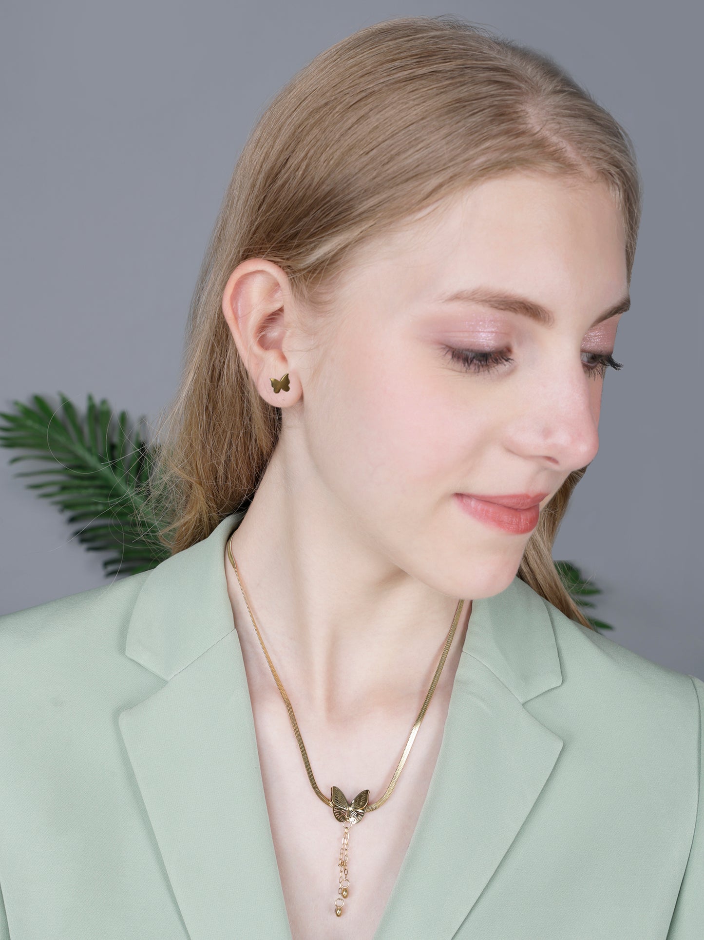 Modern gold necklace designs featuring a sleek snake chain and butterfly drop pendant with stud earrings