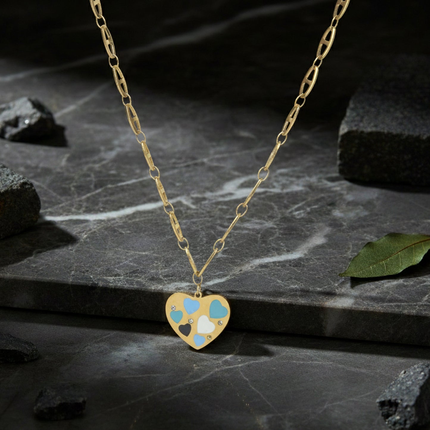 Necklace pendant designs gold finish with a multi-heart enamel charm displayed on a dark marble stone background.