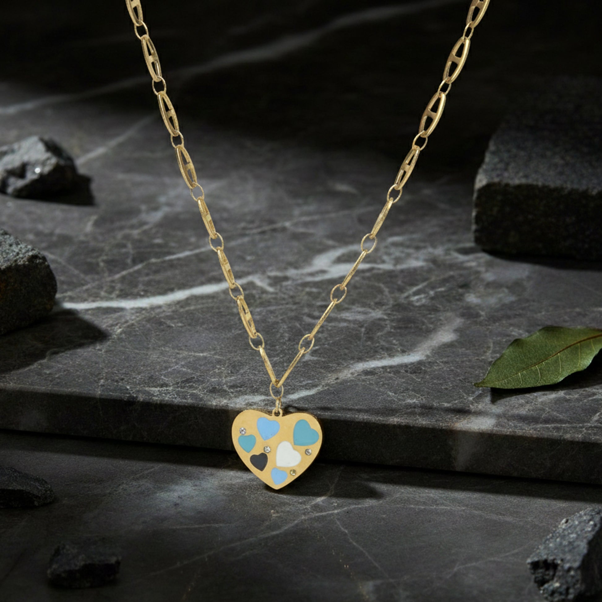Necklace pendant designs gold finish with a multi-heart enamel charm displayed on a dark marble stone background.