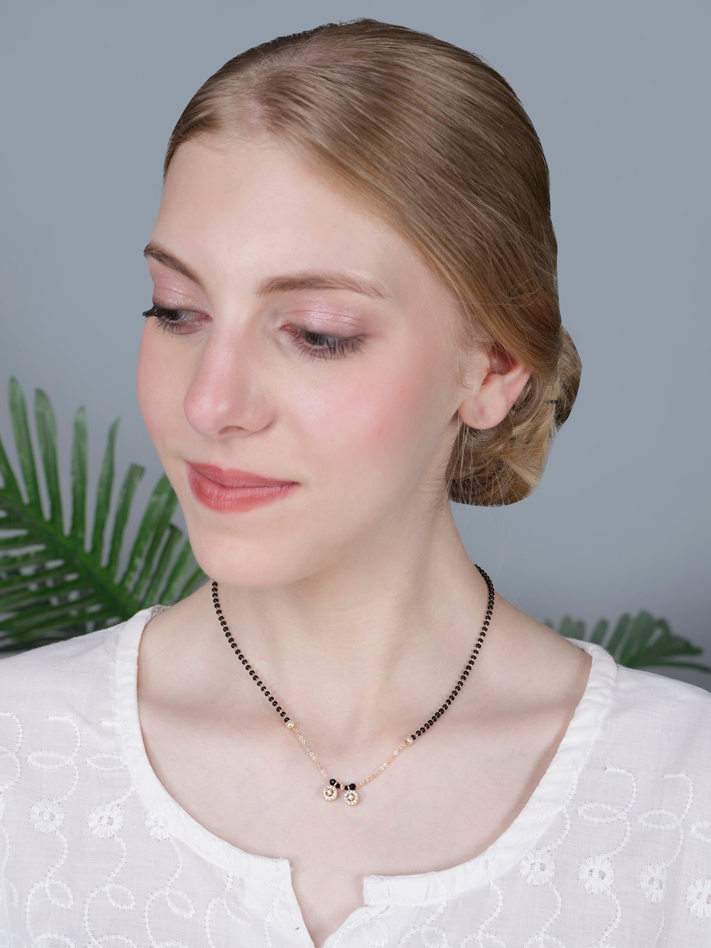 Traditional mangalsutra design featuring black beads, gold chain, pearl accents, and sparkling circular pendants