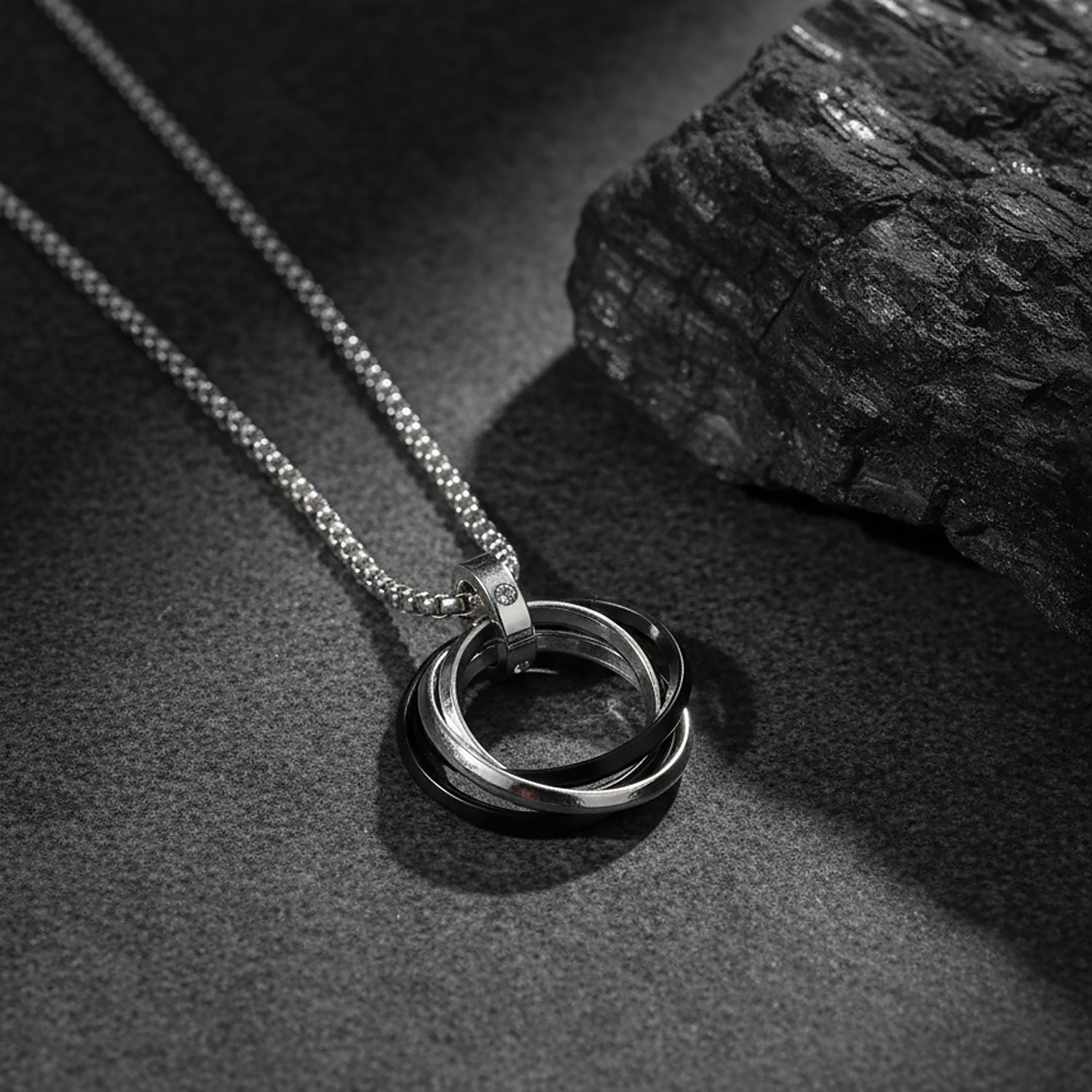 Elegant silver pendant necklace featuring triple-ring charm